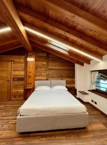 a large bed in a room with wooden ceilings at La Louye su La Goumba in Pontboset