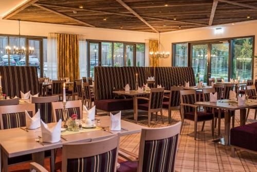 a dining room with tables and chairs and windows at Göbels Schlosshotel "Prinz von Hessen" in Friedewald