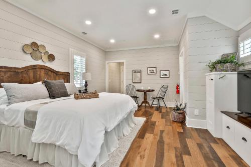 a white bedroom with a large bed and a table at The Cottages at Laurel Brooke in Peachtree City