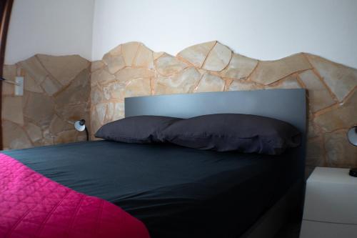 a bedroom with a large bed with a wooden headboard at Appartamento Azzurra in Melendugno