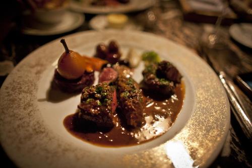 a white plate with food on a table at Auberge du Raisin in Cully