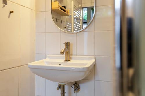 a bathroom with a white sink and a mirror at B&B Hendricus in Hoofddorp