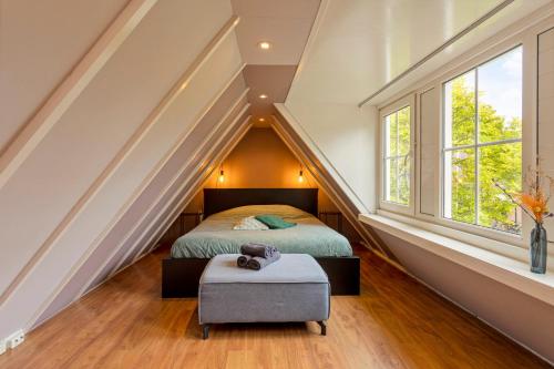 een slaapkamer op zolder met een bed en 2 ramen bij B&B Hendricus in Hoofddorp