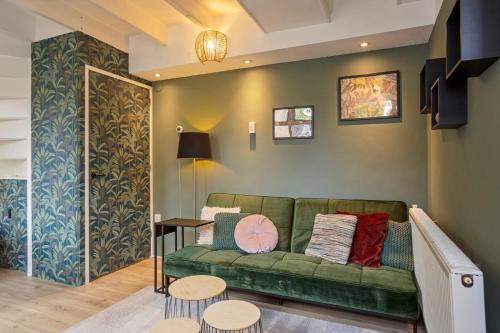 a living room with a green couch and two tables at B&B Hendricus in Hoofddorp