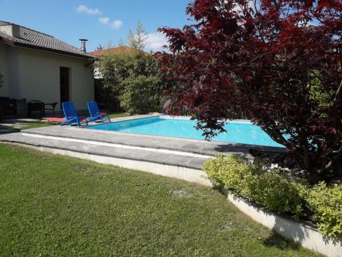 una piscina con due sedie blu in un cortile di RESIDENZA BERETTA Como Lake -A- a Orsenigo