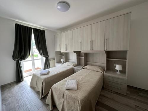 um quarto com 2 camas e uma grande janela em Appartamento Eugenio em Colico