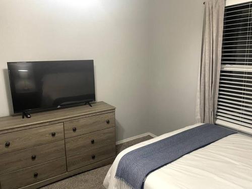 a bedroom with a dresser with a flat screen tv on it at Luxury Modern Condo by the Lake - Succulent Way in Branson