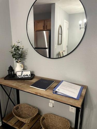 a table with a mirror and a table with two chairs at Luxury Modern Condo by the Lake - Succulent Way in Branson