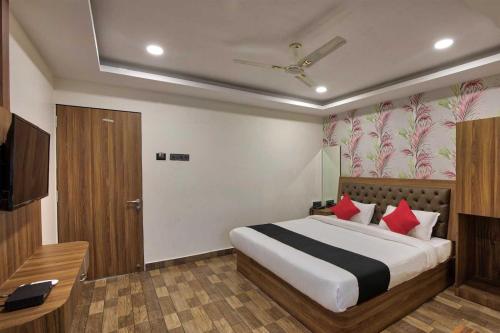 1 dormitorio con 1 cama grande con almohadas rojas en Collection O Hotel Shagun Palace, en Bhopal