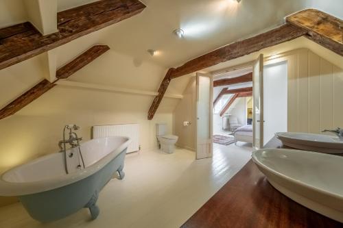 Un baño con dos lavabos y una bañera. en Alice House, en Burnham Market