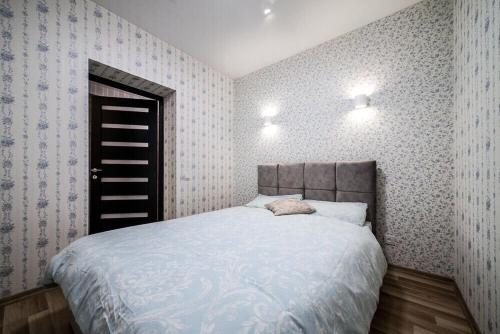 a bedroom with a large bed in a room with wallpaper at Viktoria Garden apartment in Lviv