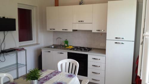 a small kitchen with white cabinets and a table and a table and a tableablish at Casa Vacanze Mari in San Vito lo Capo