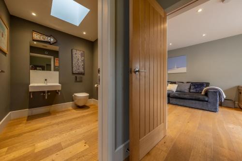 ein Bad mit einem WC und einem Sofa in einem Zimmer in der Unterkunft 5 Manor Farm Barns in Brancaster