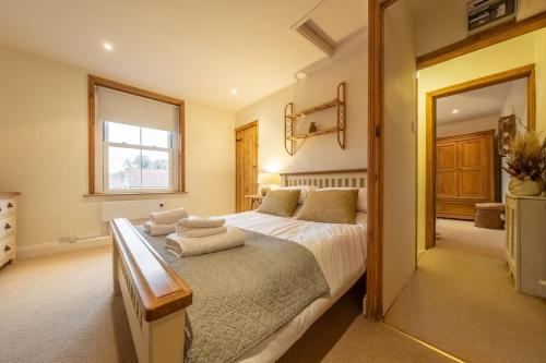 a bedroom with a large bed with towels on it at Maurice Cottage in Docking