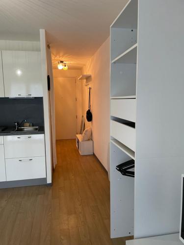 a kitchen with white cabinets and a sink in a room at Le jardin de Broceliande in Ploërmel