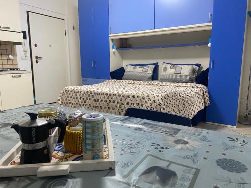 Dormitorio con cama y bandeja de comida en Monolocale IL GRIFO, en Albisola Superiore
