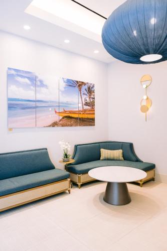 a living room with two couches and a table at Waikiki Malia in Honolulu