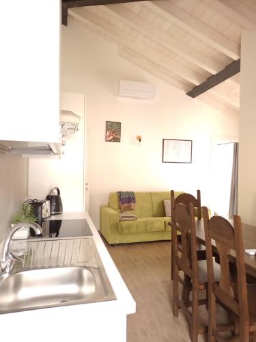 a kitchen and a living room with a couch at appartamenti Residenza 1928 in Tremosine Sul Garda