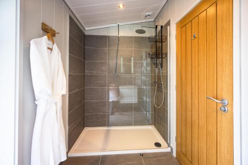 a bathroom with a shower with a glass door at Ingol Lodge 2 in Ingoldisthorpe