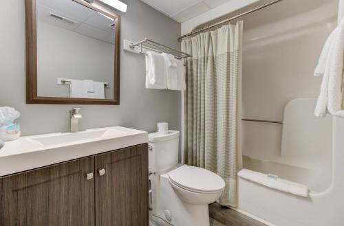 a bathroom with a toilet and a sink and a mirror at 0703 Atlantic Retreat by Atlantic Towers in Carolina Beach