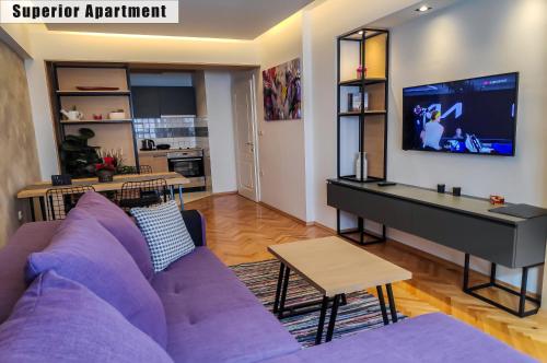 a living room with a purple couch and a piano at Apartments FANTASY in Ohrid