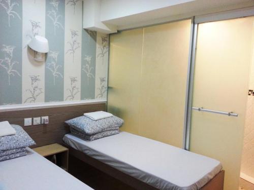 a small room with two beds and a mirror at K & B Hostel in Hong Kong