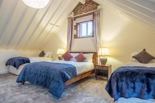 Un dormitorio con dos camas y una ventana. en Primrose Farm Barn 14, en Roughton