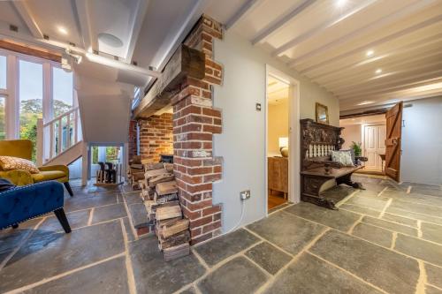 sala de estar con pared de ladrillo y chimenea en Primrose Farm Barn 14, en Roughton