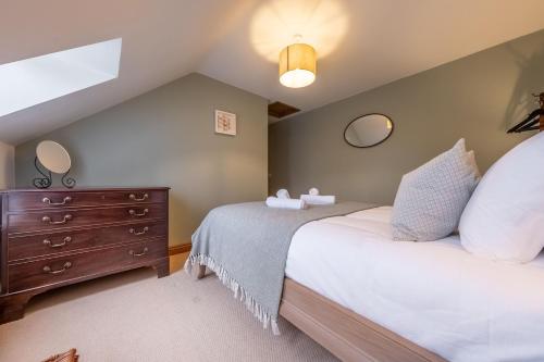 um quarto com 2 camas e uma cómoda castanha em Sandpiper Lodge em Little Walsingham
