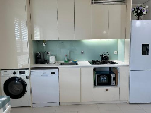 a kitchen with white cabinets and a washer and dryer at YingYing Apartamento with a free parking space in Lisbon
