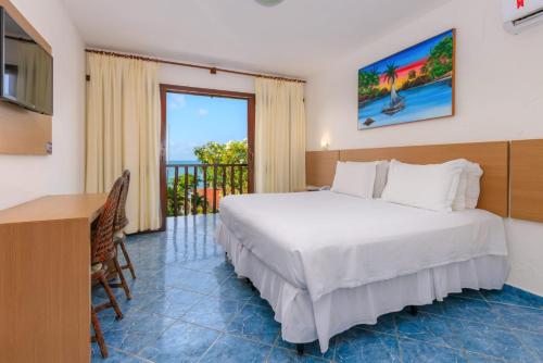 um quarto com uma cama, uma secretária e uma janela em D Beach Resort em Natal