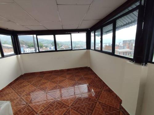 an empty room with windows and a tiled floor at Lugar acogedor, Ideal para estar en familia. in Santa Rosa de Cabal