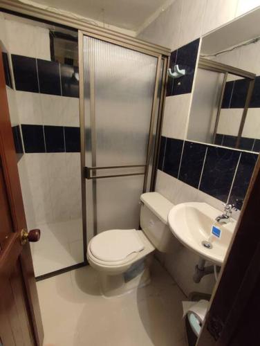 a bathroom with a toilet and a shower and a sink at Lugar acogedor, Ideal para estar en familia. in Santa Rosa de Cabal