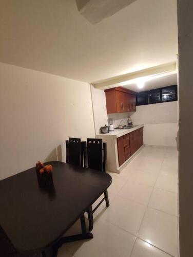 a kitchen with a black table and a kitchen with at Lugar acogedor, Ideal para estar en familia. in Santa Rosa de Cabal