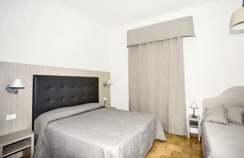a bedroom with a large bed and aermottermottermottermott at Hotel Lucerna in Castiglione della Pescaia