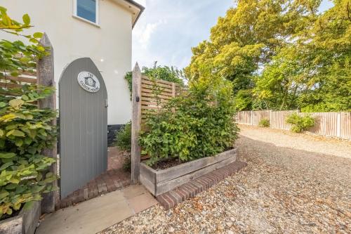 a gate with a clock on the side of a house at The Clockhouse in North Lopham