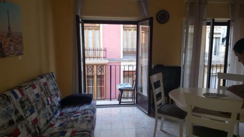 a living room with a couch and a table and a balcony at Ayuntamiento Alicante in Alicante