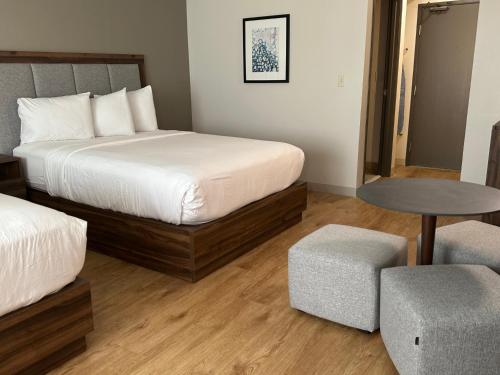 a bedroom with a bed and a table and a chair at Wingate by Wyndham Hattiesburg in Hattiesburg