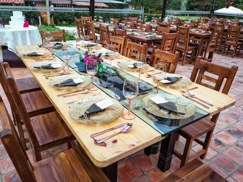 a long wooden table with wine glasses on it at Hospedaje Villa Eucalyptus in Nobsa