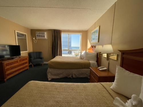 a hotel room with two beds and a television at Polynesian Oceanfront Hotel in Myrtle Beach