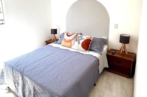 a bedroom with a blue bed with pillows on it at Espectacular Apartamento en Marinilla, Wifi 200MB in Marinilla