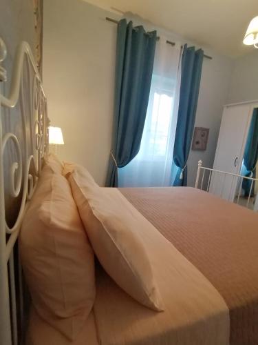 a bedroom with a large bed with blue curtains at B&B PLANO DE LACZARULO in Acciaroli
