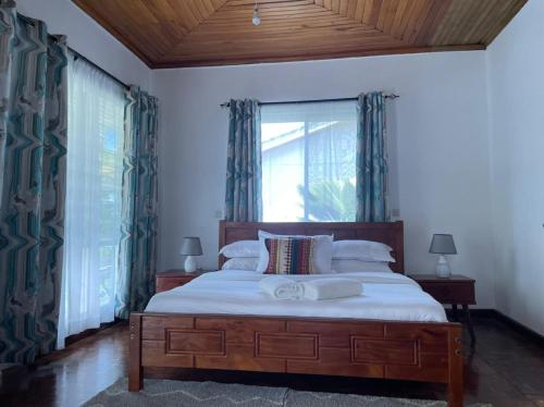 a bedroom with a large bed and a window at El Tessa garden/serviced apartment in Kisumu