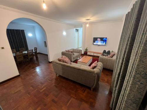 a living room with two couches and a tv at El Tessa garden/serviced apartment in Kisumu