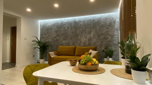 un soggiorno con divano e tavolo con cesto di frutta di Apartament nad jeziorem a Przemyśl