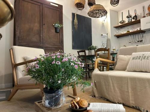 ein Wohnzimmer mit einem Sofa und einem Tisch mit Blumen in der Unterkunft MARIREU in Castiadas