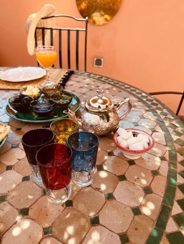 a table with plates and glasses on top of it at Riad Allal in Marrakech