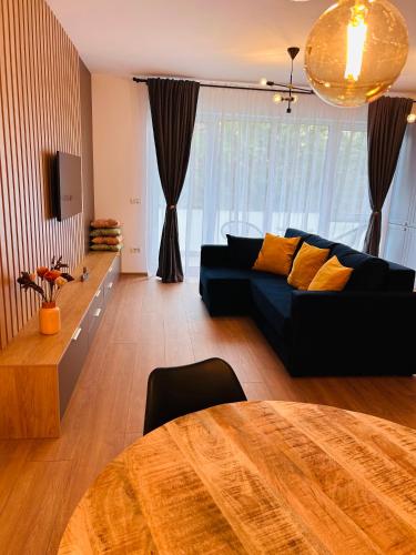 uma sala de estar com um sofá e uma mesa em Brand new, feel at home residence em Timisoara