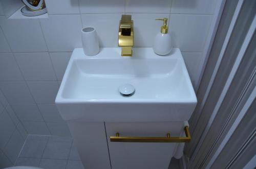 オストゥーニにあるLa maison de Roseの白いバスルームの洗面台(金の蛇口付)