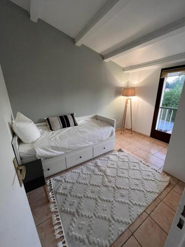 - une chambre avec un lit, une fenêtre et un tapis dans l'établissement La Brise Marine, à Cogolin